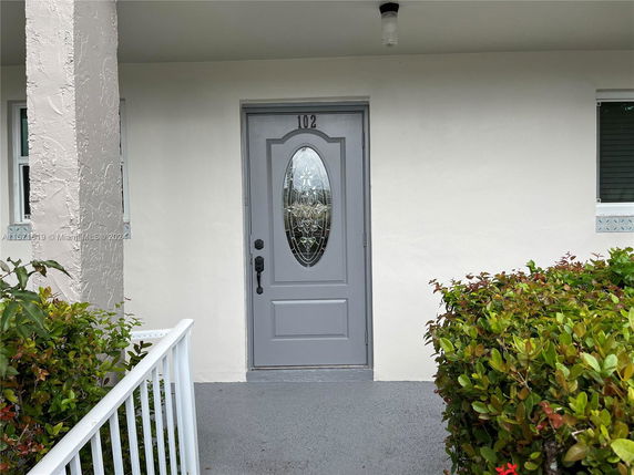 Front view of a house with a gray door and white walls.