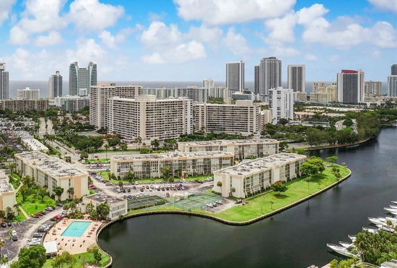 Panoramic view of a cityscape with multiple high-rise buildings and water in the foreground.