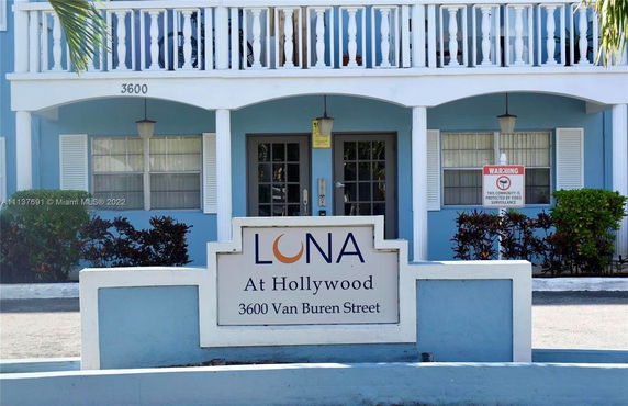 Front view of a blue two-story building with a balcony.