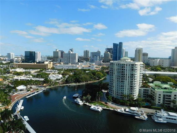 Panoramic view of a river with boats and surrounding city skyline.