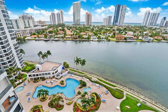 Panoramic view from a building overlooking a river and cityscape with high-rise buildings.