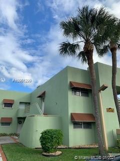Front view of a green two-story building with brown awnings.