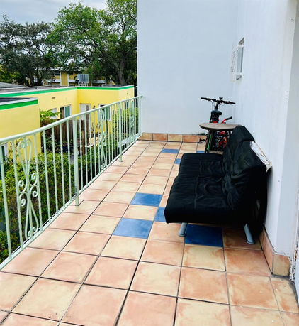 View from the balcony towards neighboring houses and trees.