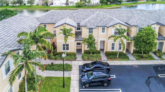 Front view of a residential building with parked cars.