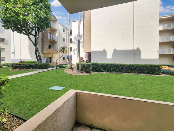View of apartment buildings with balconies and surrounding landscaping.
