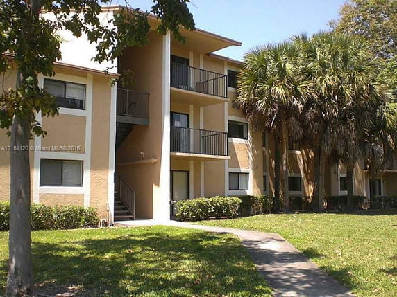 Front view of a multi-story apartment building with balconies.