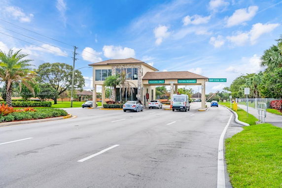 Front view of a guardhouse and entrance gate with multiple lanes for vehicles.
