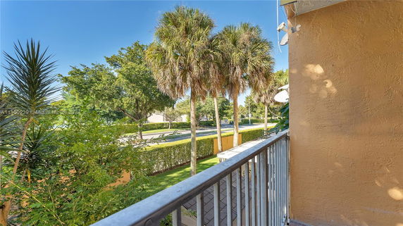View from a balcony showing trees and a street.