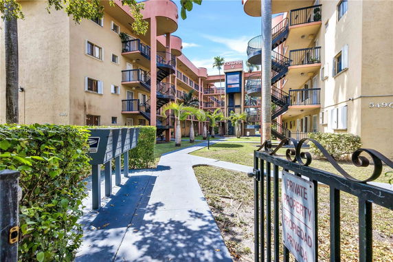 Front view of a multi-story apartment complex with exterior staircases.