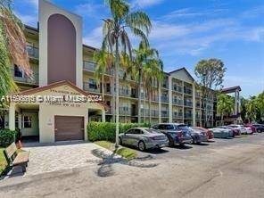Front view of a multi-story residential building with parking area.