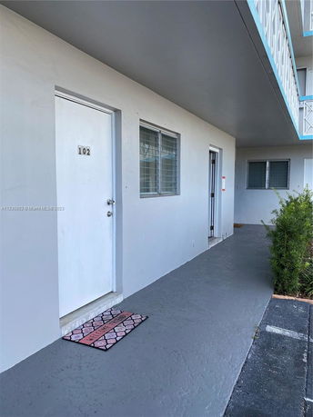 Front view of a building entrance with door number 102.