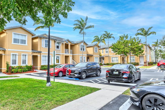 Outdoor parking area in front of a two-story residential building.