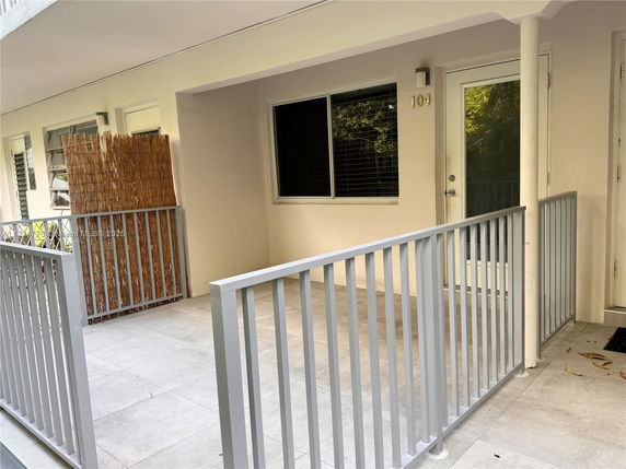 Front view of a building with a balcony area and metal railing.