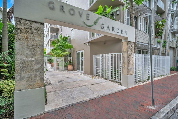 Front view of a modern building entrance with the name 'Grove Garden' and a gated entry.