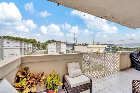View from a balcony overlooking nearby buildings and open sky.