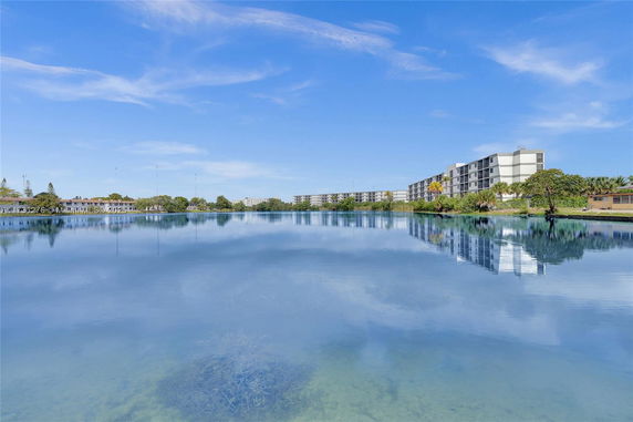 View across a lake towards modern residential buildings.