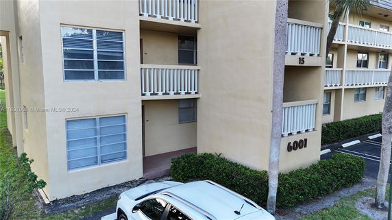 Exterior view of a multi-story residential building with beige walls and balconies.