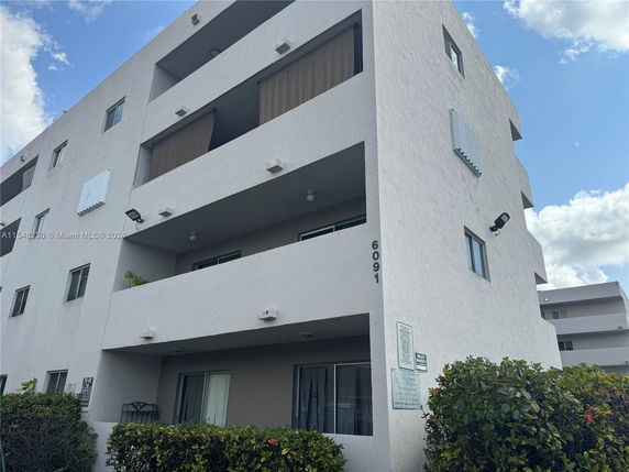 Front view of a multi-story apartment building with balconies.