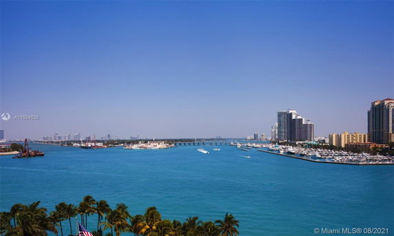 Wide angle view of a bay, tall buildings, and boats on the water.