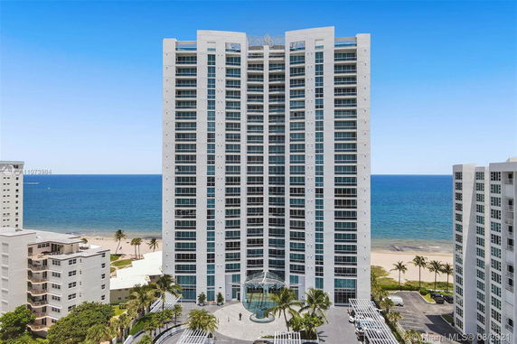Front view of a tall beachfront condominium building.