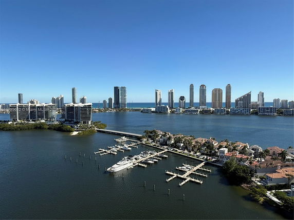 Panoramic view of buildings and waterfront area with yachts.