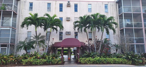 Front view of a multi-story residential building with a covered entrance.