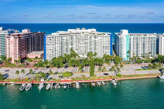 Front view of a large waterfront apartment complex with a curved facade.