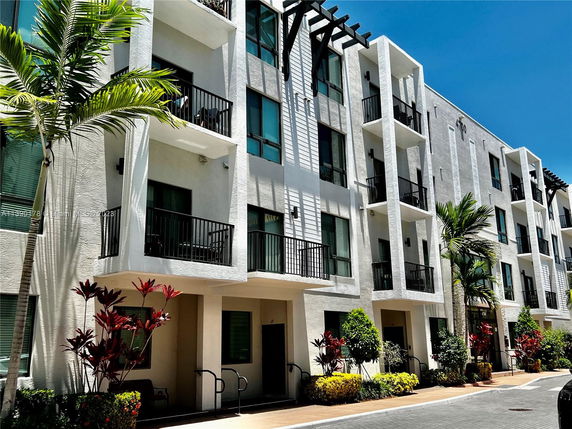 Front view of a multi-story residential building with balconies and modern design.