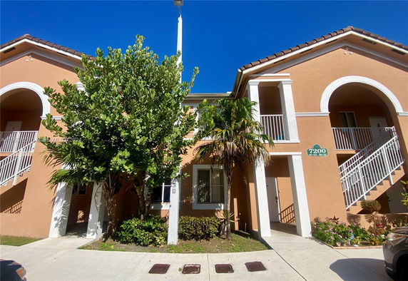 Front view of a two-story building with staircases and balconies.