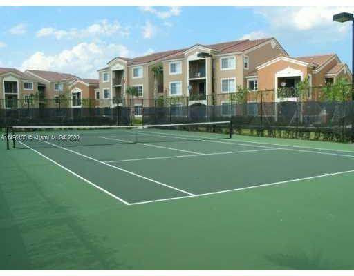 Tennis court in front of residential buildings.