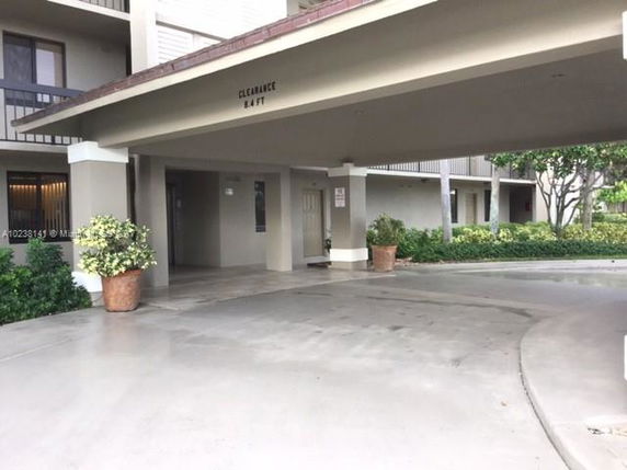 Front view of a building with a covered entrance and clearance height signage.