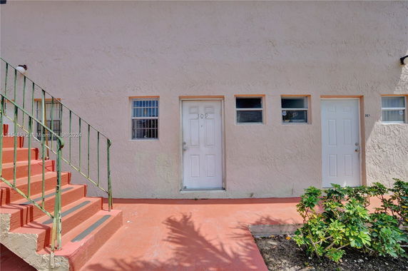 Front view of a building entrance with stairs and doors.