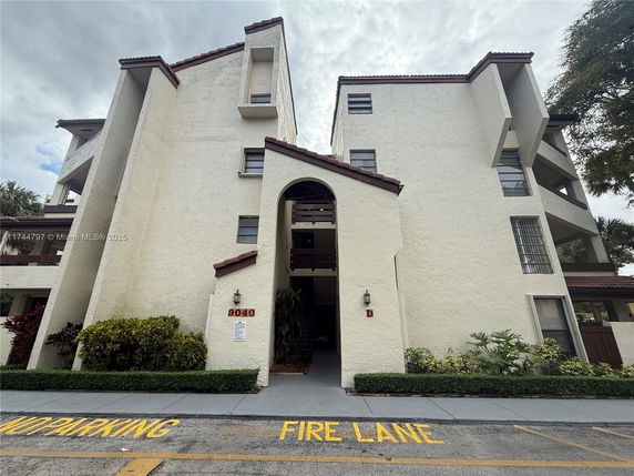 Front view of a multi-story building with distinct architectural features and an archway entrance.