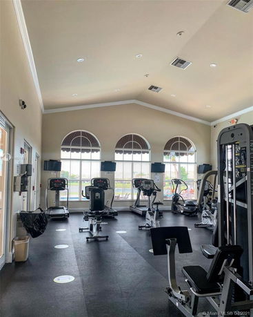 Indoor gym area with exercise equipment and large windows.
