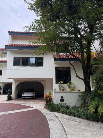 Front view of a multi-story house with a red-tiled roof and a garage.