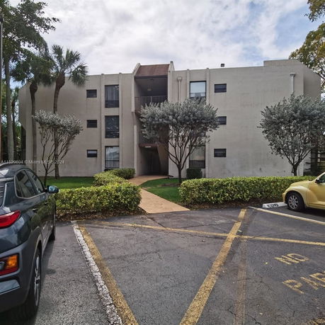 Front view of a multi-story building with a central entrance and pathways.