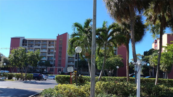 Front view of a multi-story residential building with balconies and a pink facade.