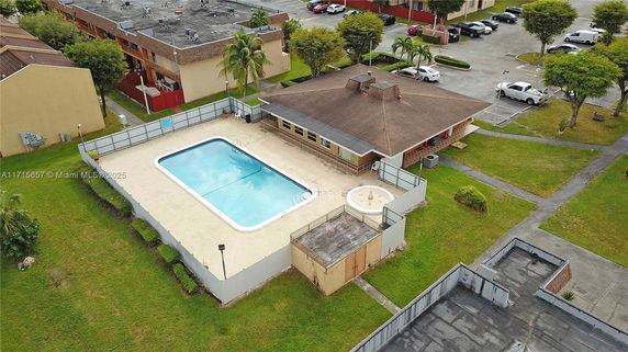 Aerial view of a community swimming pool area beside a building.