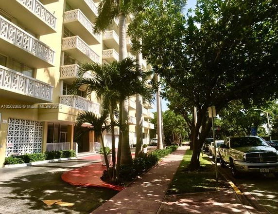Front view of a multi-story building with decorative balcony railings.