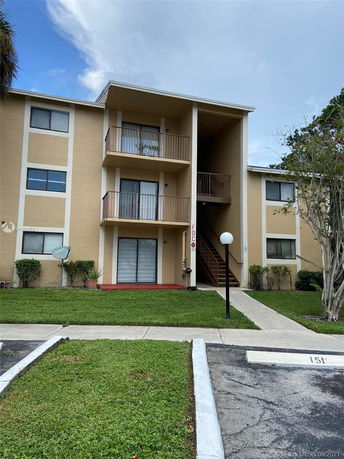 Front view of a three-story apartment building with balconies.
