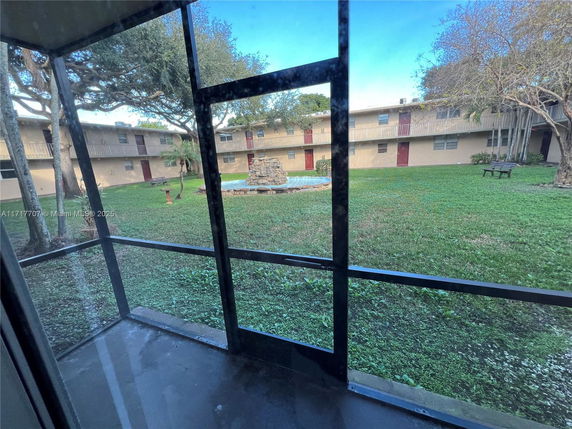 View from inside looking out to a courtyard with two-story buildings surrounding it.