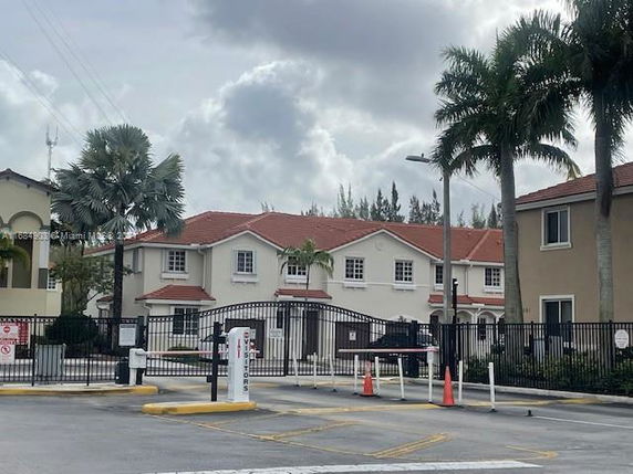 Front view of a two-story residential building with a gated entrance.