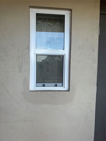 View of a window with white frame on a beige wall.