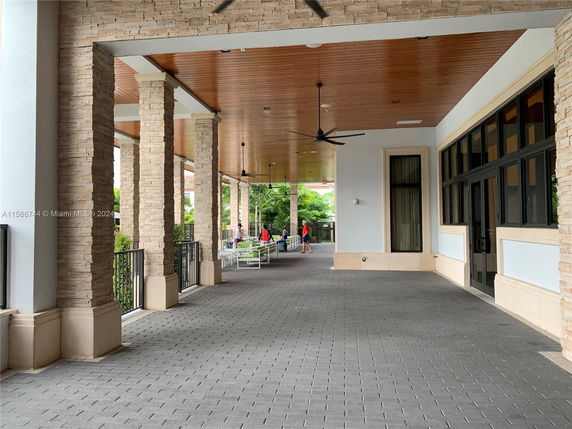Covered outdoor area with stone columns and tile flooring