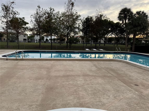 Outdoor swimming pool area with surrounding trees.