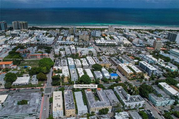 Aerial view of a coastal city with numerous buildings and the ocean in the background.