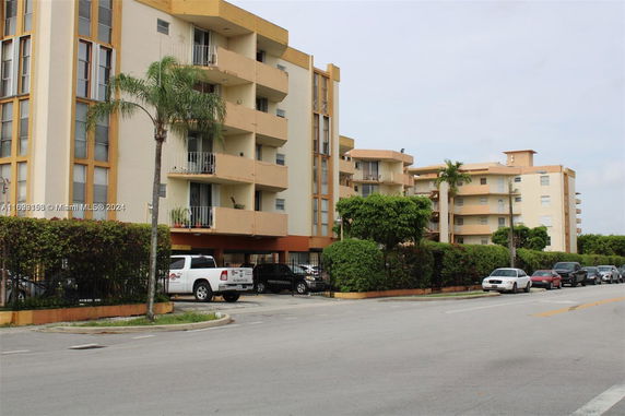 Front view of a multi-story apartment building with balconies.