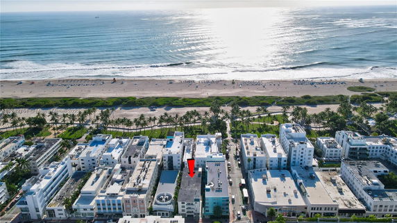 Aerial view of buildings near a beach with ocean in the background.