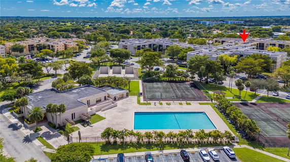 Aerial view of a neighborhood with buildings, swimming pool, and sports courts.