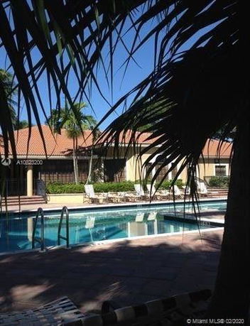 View of a swimming pool with a building in the background.